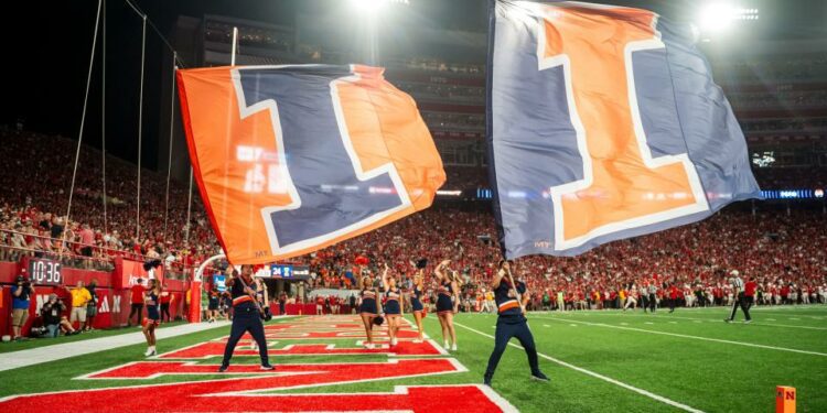 Sep 20, 2024; Lincoln, Nebraska, USA; Illinois Fighting Illini flags are waved after a touchdown against the Nebraska Cornhuskers during the fourth quarter at Memorial Stadium. Mandatory Credit: Dylan Widger-Imagn Images