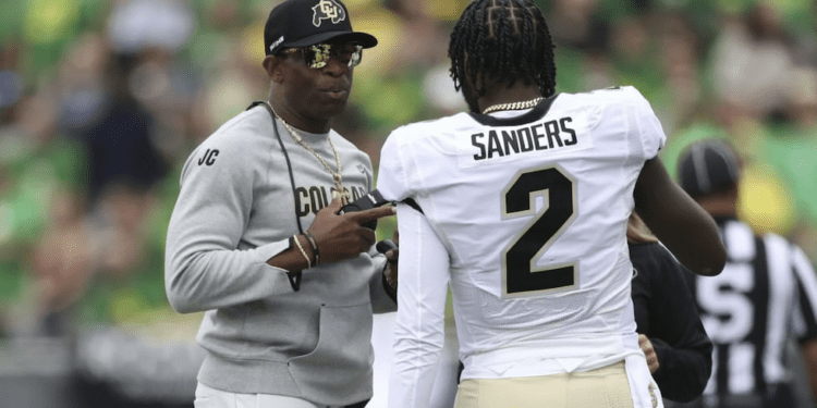 Colorado head coach Deion Sanders talks with his son and quarterback Shedeur Sanders during...