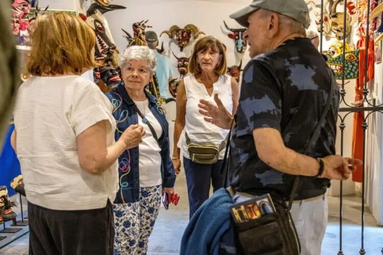 A group of foreigners talking in the middle of an art room.