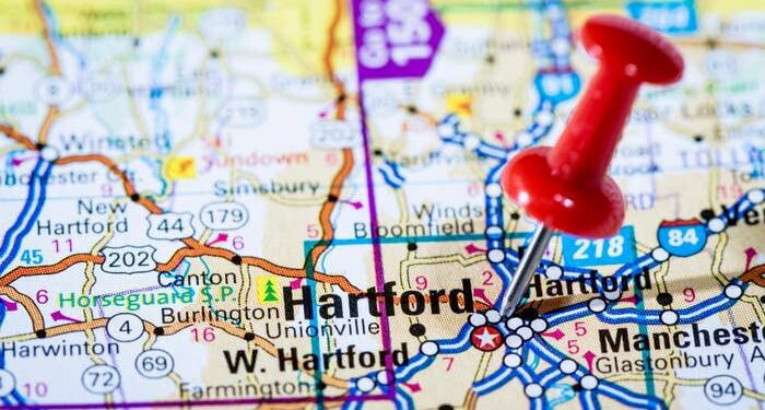 Close-up of a map showing Hartford, with a red pushpin marking the location. Nearby cities like New Hartford, Canton, and Manchester are also visible