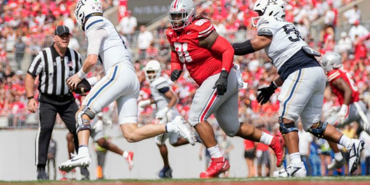 Aug 31, 2024; Columbus, OH, USA; Ohio State Buckeyes defensive tackle Tyleik Williams (91) pursues Akron Zips quarterback Ben Finley (10) during the NCAA football game at Ohio Stadium. Ohio State won 52-6.