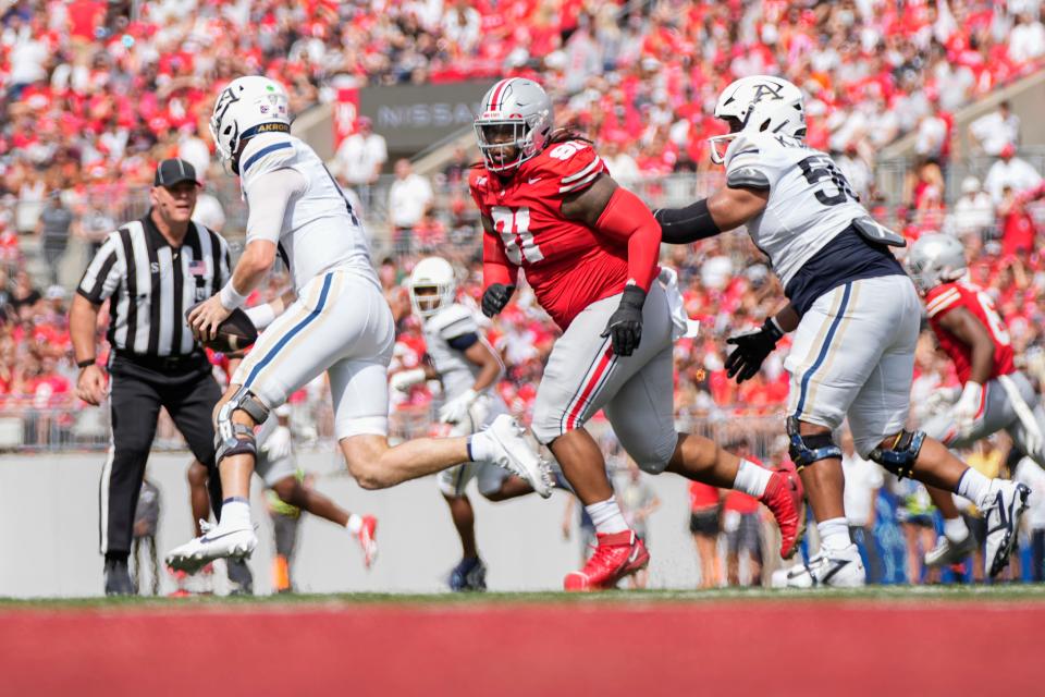 Aug 31, 2024; Columbus, OH, USA; Ohio State Buckeyes defensive tackle Tyleik Williams (91) pursues Akron Zips quarterback Ben Finley (10) during the NCAA football game at Ohio Stadium. Ohio State won 52-6.