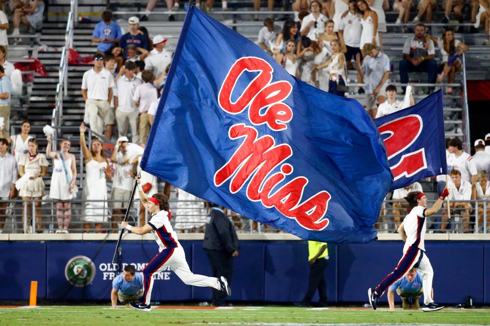 Aug 31, 2024; Oxford, Mississippi, USA; Mississippi Rebels Cheerleaders run the Ole Miss flag across the field after a touchdown during the second half against the Furman Paladins at Vaught-Hemingway Stadium. Mandatory Credit: Petre Thomas-USA TODAY Sports