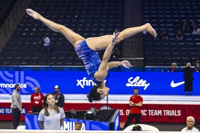 A gymnast turns a somersault in midair