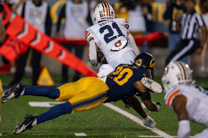 Sep 9, 2023; Berkeley, California, USA; Auburn Tigers running back Brian Battie (21) is upended by California Golden Bears defensive back Cam Sidney (20) during the first quarter at California Memorial Stadium. Mandatory Credit: Neville E. Guard-USA TODAY Sports  