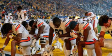 Sep 9, 2023; Berkeley, California, USA; Auburn Tigers defensive lineman Quientrail Jamison-Travis (97) and Auburn Tigers safety Donovan Kaufman (5) and teammates kneel before the start of that game against the California Golden Bears at California Memorial Stadium. Mandatory Credit: Neville E. Guard-USA TODAY Sports