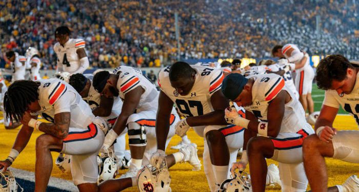 Sep 9, 2023; Berkeley, California, USA; Auburn Tigers defensive lineman Quientrail Jamison-Travis (97) and Auburn Tigers safety Donovan Kaufman (5) and teammates kneel before the start of that game against the California Golden Bears at California Memorial Stadium. Mandatory Credit: Neville E. Guard-USA TODAY Sports