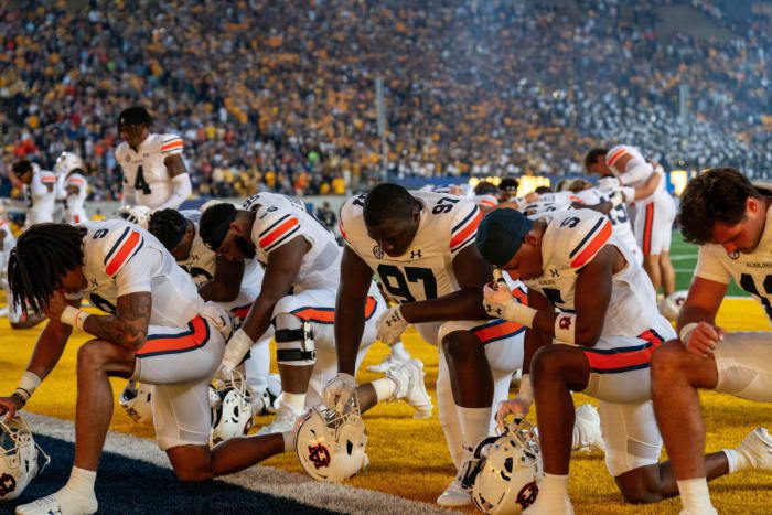 Sep 9, 2023; Berkeley, California, USA; Auburn Tigers defensive lineman Quientrail Jamison-Travis (97) and Auburn Tigers safety Donovan Kaufman (5) and teammates kneel before the start of that game against the California Golden Bears at California Memorial Stadium. Mandatory Credit: Neville E. Guard-USA TODAY Sports