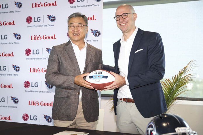 Tennessee Titans Chief Operating Officer Daniel Werly presents an honorary football to LG Electronics North America CEO Chris Jung at a signing ceremony to celebrate the renewal of their partnership on Monday, July 8, 2024 in Nashville, Tenn. (Davis Stevens/AP Content Services for LG Electronics USA) 