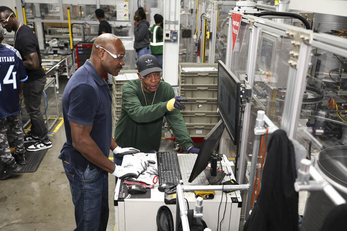 Tennessee Titans alumni Jevon Kearse (left, back) and Keith Bulluck (center) visit LG Electronics factory in Clarksville, TN to celebrate the extension of LG and the Titans partnership on Monday, July 8, 2024 (Davis Stevens/AP Content Services for LG Electronics USA) 