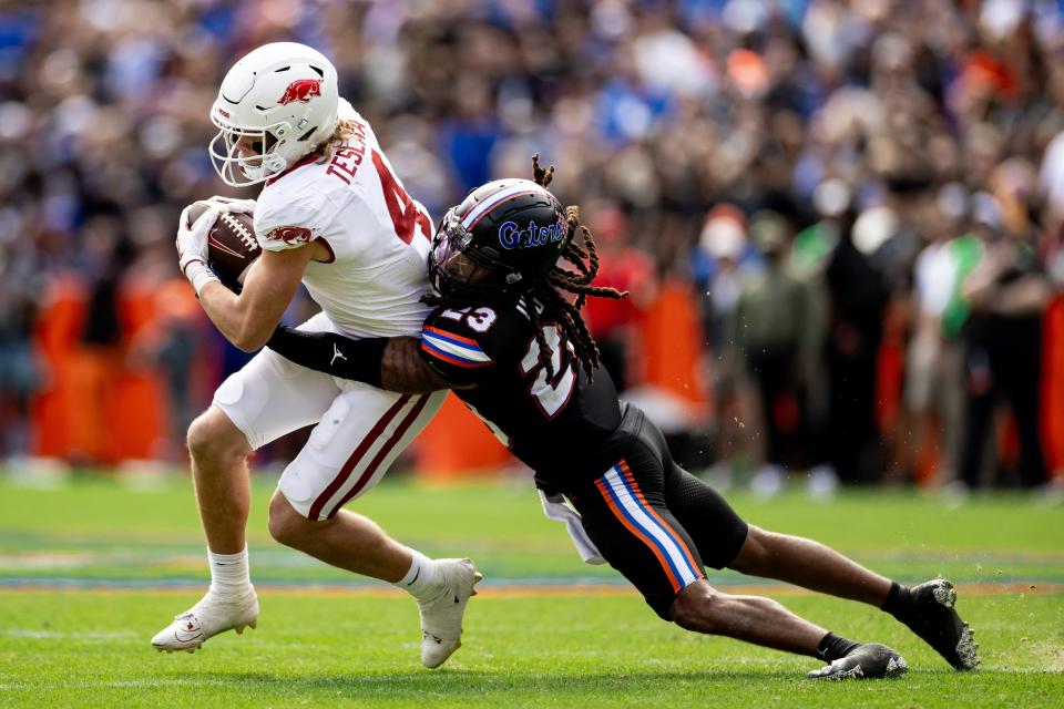 Florida Gators cornerback Jaydon Hill (23) tackles Arkansas Razorbacks wide receiver Isaac TeSlaa (4) during the second half at Steve Spurrier Field at Ben Hill Griffin Stadium in Gainesville, FL on Saturday, November 4, 2023. [Matt Pendleton/Gainesville Sun]