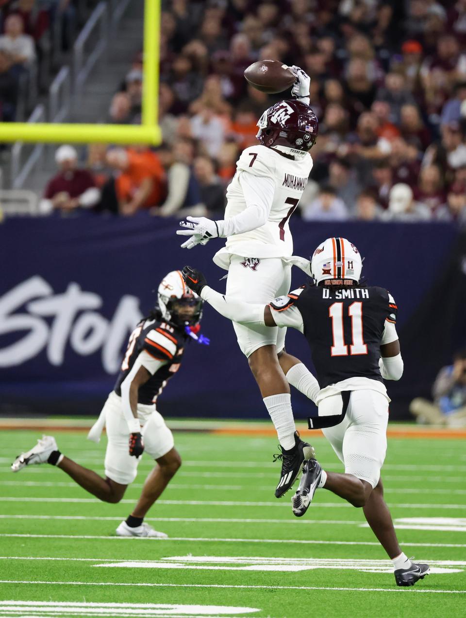 Dec 27, 2023; Houston, TX, USA; Texas A&M Aggies wide receiver Moose Muhammad III (7) catches a pass against Oklahoma State Cowboys cornerback Dylan Smith (11) in the second quarter at NRG Stadium. Mandatory Credit: Thomas Shea-USA TODAY Sports