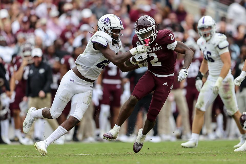 COLLEGE STATION, TEXAS - NOVEMBER 18: Rueben Owens #2 of the Texas A&M Aggies runs the ball while being tackled by Izaiah Kelley #25 of the Abilene Christian Wildcats in the second half at Kyle Field on November 18, 2023 in College Station, Texas. (Photo by Tim Warner/Getty Images)