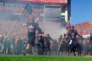 Nebraska Cornhuskers defensive end Jack Gangwish (95) and Nebraska Cornhuskers running back Jordan Stevenson (2) lead the team onto the field against the Northwestern Wildcats at Memorial Stadium. 