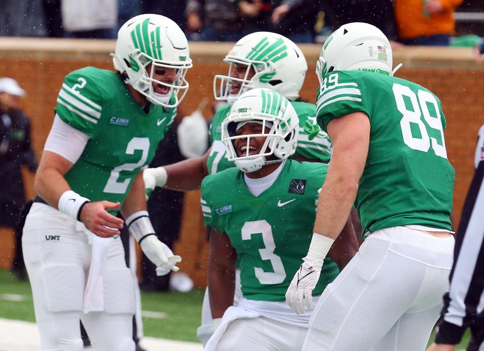 DENTON, TEXAS - NOVEMBER 27: Austin Aune #2 and Asher Alberding #89 of the North Texas Mean Green celebrate the second quarter touchdown by DeAndre Torrey #3 against the UTSA Roadrunners at Apogee Stadium on November 27, 2021 in Denton, Texas. (Photo by Richard Rodriguez/Getty Images)