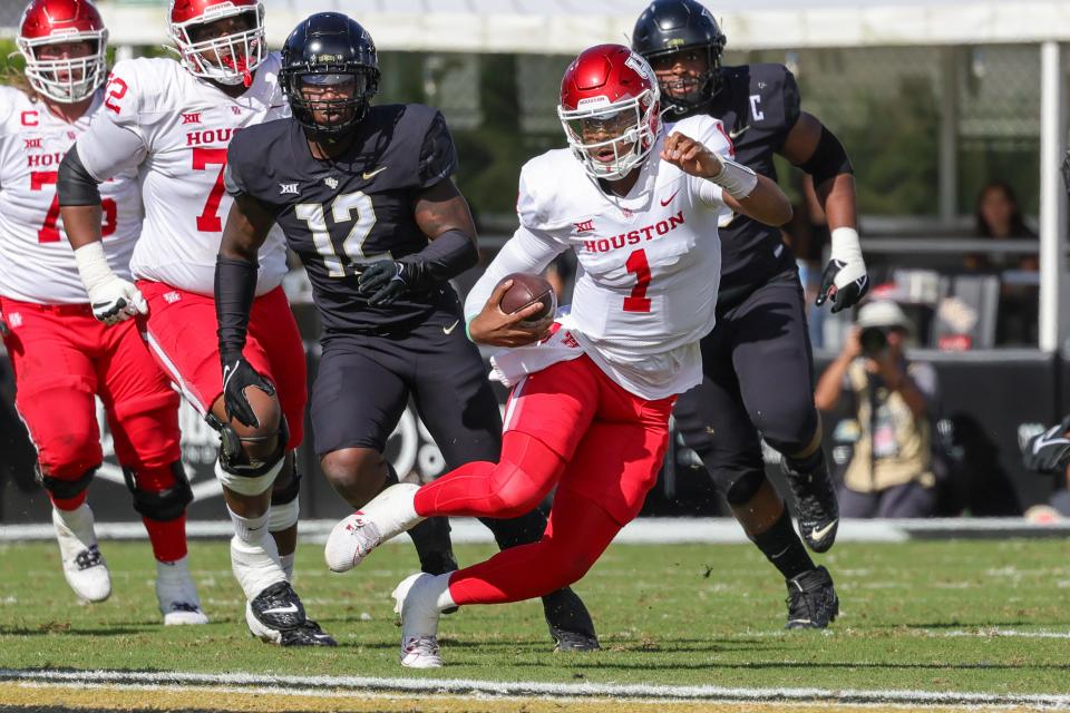 Nov 25, 2023; Orlando, Florida, USA; Houston Cougars quarterback Donovan Smith (1) runs the ball in front of UCF Knights defensive end Shaun Peterson Jr. (12) during the second quarter at FBC Mortgage Stadium. Mandatory Credit: Mike Watters-USA TODAY Sports