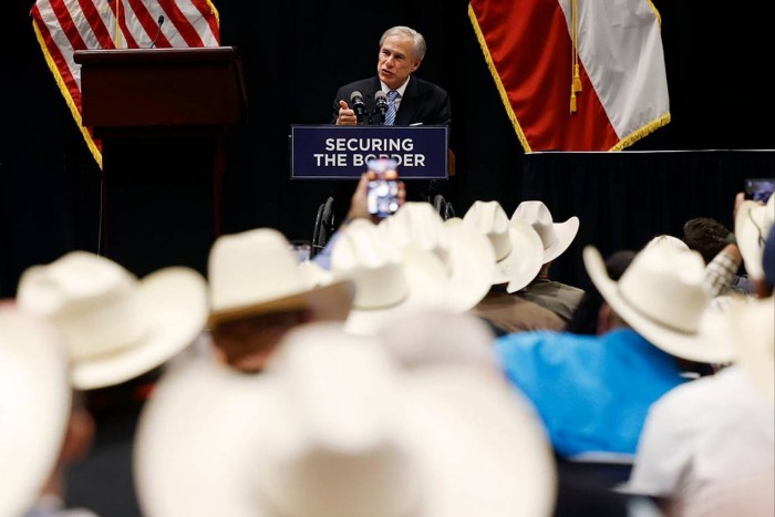 Greg Abbott stands at a podium 