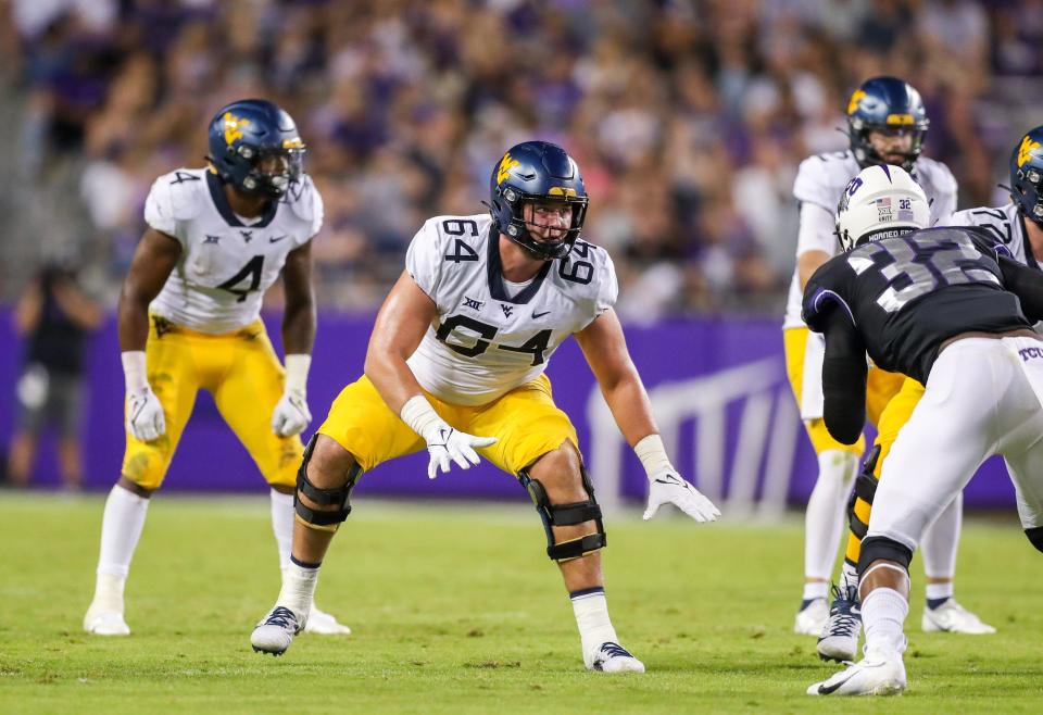 Oct 23, 2021; Fort Worth, Texas, USA; West Virginia Mountaineers offensive lineman Wyatt Milum (64) steps back to block during the third quarter against the TCU Horned Frogs at Amon G. Carter Stadium. Mandatory Credit: Ben Queen-USA TODAY Sports