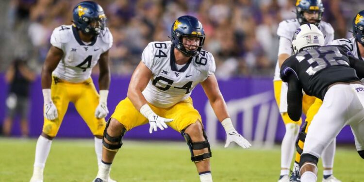 Oct 23, 2021; Fort Worth, Texas, USA; West Virginia Mountaineers offensive lineman Wyatt Milum (64) steps back to block during the third quarter against the TCU Horned Frogs at Amon G. Carter Stadium. Mandatory Credit: Ben Queen-USA TODAY Sports