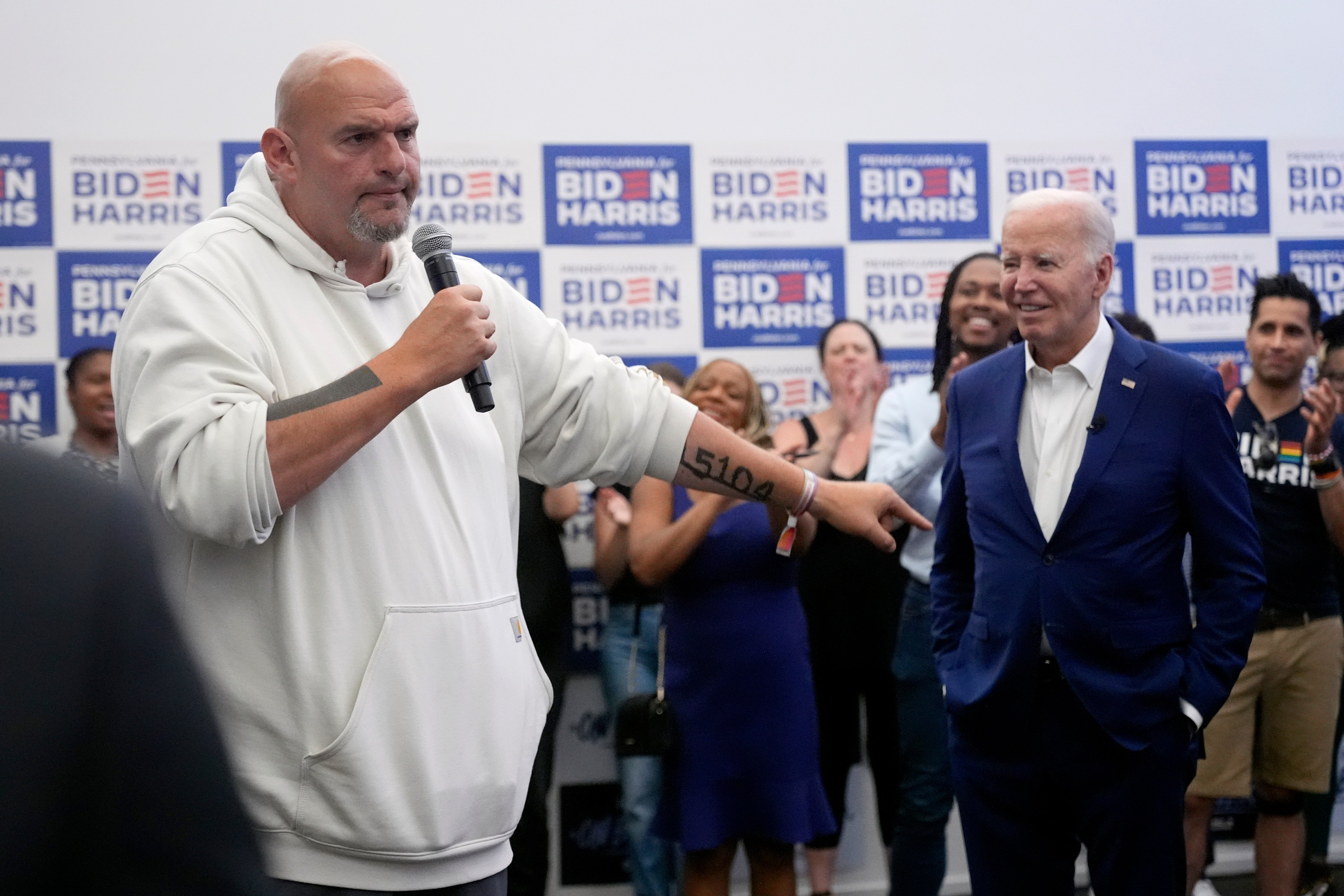 President Joe Biden, right, listens as Sen. John Fetterman, D-Pa., speaks at a campaign office in Philadelphia on Sunday, July 7, 2024.