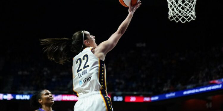 May 14, 2024; Uncasville, Connecticut, USA; Indiana Fever guard Caitlin Clark (22) scores her first regular season basket against the Connecticut Sun in the second quarter at Mohegan Sun Arena. Mandatory Credit: David Butler II-USA TODAY Sports