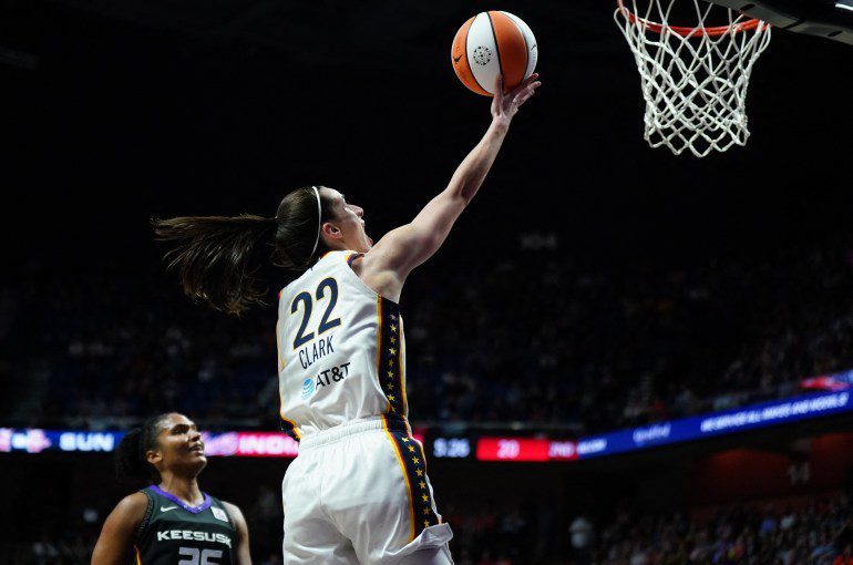 May 14, 2024; Uncasville, Connecticut, USA; Indiana Fever guard Caitlin Clark (22) scores her first regular season basket against the Connecticut Sun in the second quarter at Mohegan Sun Arena. Mandatory Credit: David Butler II-USA TODAY Sports