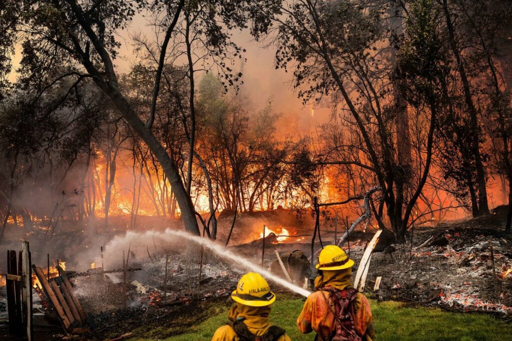 Firefighters spray water while battling the Park Fire in the Cohasset community of Butte County, California, on July 25.