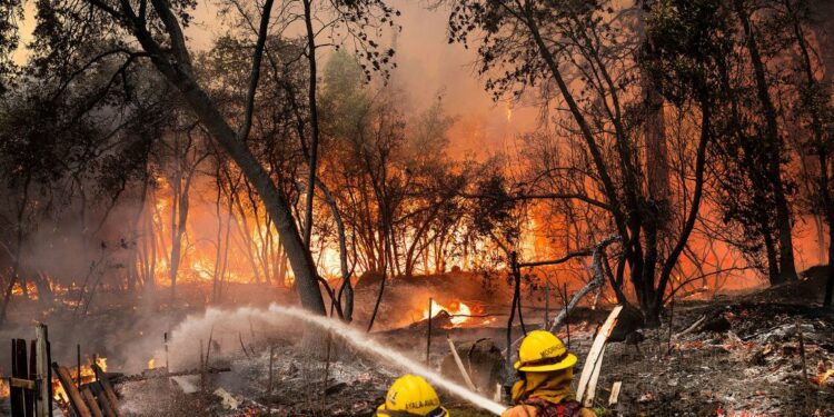 Firefighters spray water while battling the Park Fire in the Cohasset community of Butte County, California, on July 25.