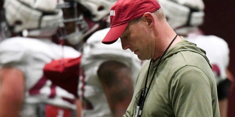 April 9, 2024; Tuscaloosa, Alabama, USA; Alabama head coach Kalen DeBoer checks his play sheet during practice in the Hank Crisp Indoor Practice Facility at the University of Alabama.