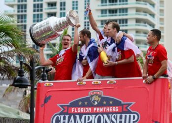 Florida Panthers center Anton Lundell (left) hoists the Stanley Cup during the team's victory parade and celebration.