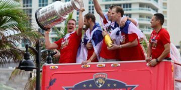 Florida Panthers center Anton Lundell (left) hoists the Stanley Cup during the team's victory parade and celebration.