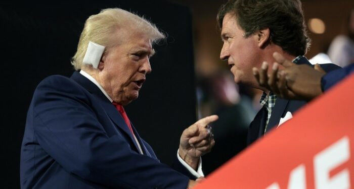 Donald Trump speaks with Tucker Carlson at the convention