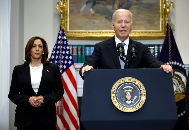 U.S. President Joe Biden delivering remarks at a podium, with Vice President Kamala Harris standing behind him