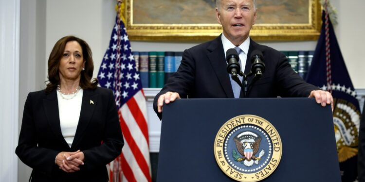 U.S. President Joe Biden delivering remarks at a podium, with Vice President Kamala Harris standing behind him