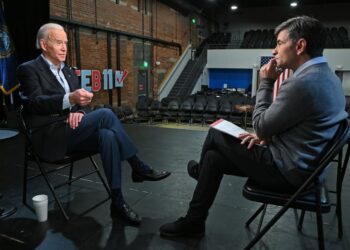 Joe Biden and George Stephanopoulos facing each other in an interview. Both men are dressed semi-casually
