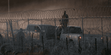 Armed personnel stand guard at the U.S.-Mexico border. - Courtesy Photo / Hope Border Institute