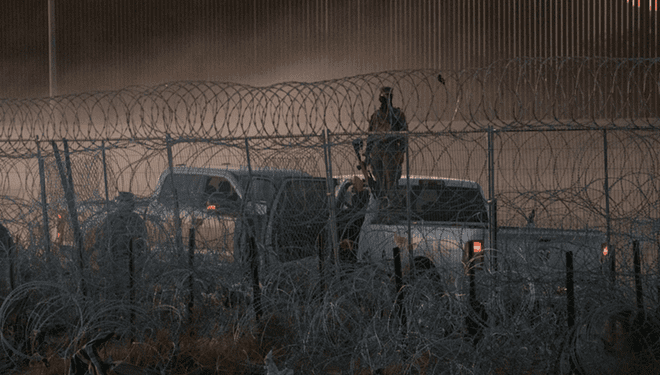 Armed personnel stand guard at the U.S.-Mexico border. - Courtesy Photo / Hope Border Institute