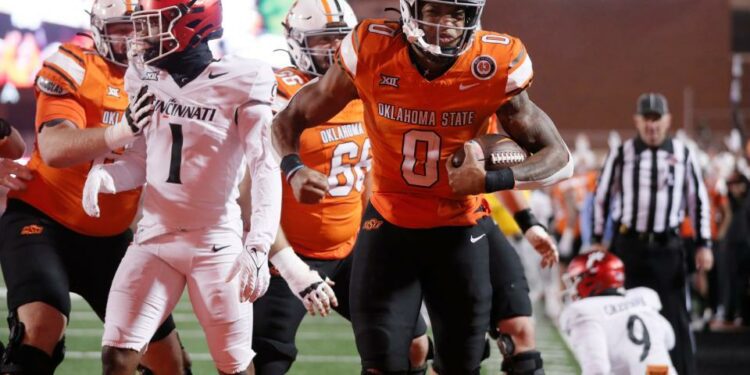 Oct 28, 2023; Stillwater, Oklahoma, USA; Oklahoma State Cowboys running back Ollie Gordon II (0) celebrstes beside Cincinnati Bearcats cornerback Jordan Young (1) after running for a touchdown the third quarter of a college football game between Oklahoma State and Cincinnati at Boone Pickens Stadium. Oklahoma State won 45-13. Mandatory Credit: Bryan Terry-USA TODAY Sports