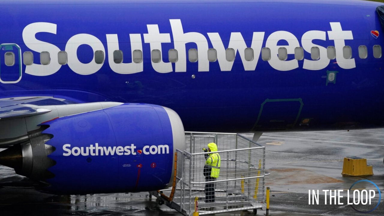 A Southwest jet is parked on a tarmac as passengers wait to board.