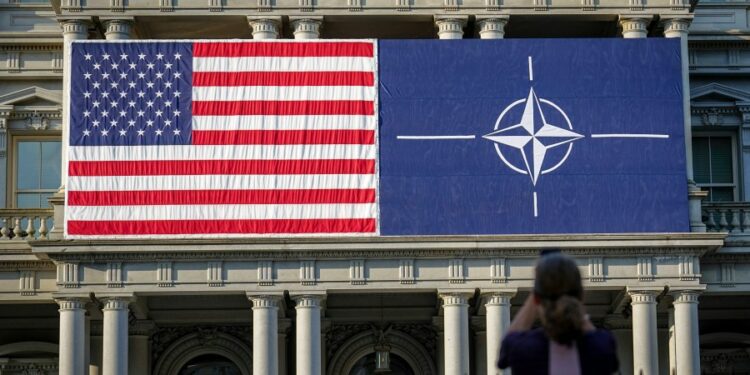 09 July 2024, USA, Washington: A passer-by takes an early morning photo of the fa'ade of the Eisenhower Building with the US and NATO flags. The NATO summit begins with the celebrations to mark the 75th anniversary of the defense alliance. Photo by: Kay Nietfeld/picture-alliance/dpa/AP Images