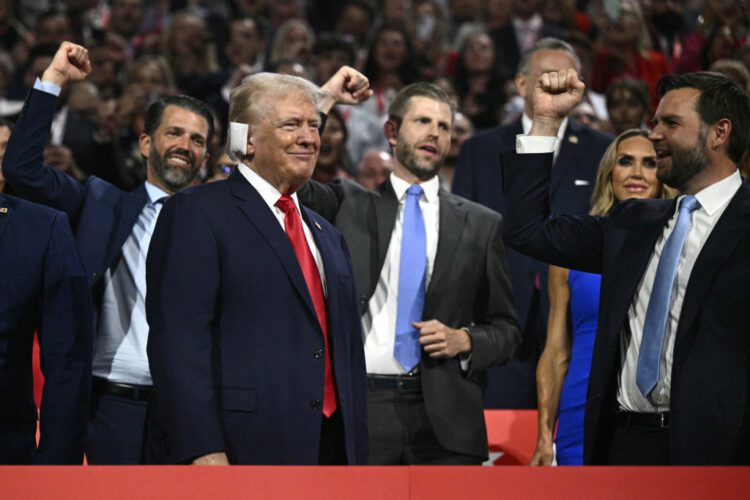 Donald Trump smiles as he is cheered on by his running mate J.D. Vance and his sons Donald Trump Jr. and Eric Trump during the first day of the 2024 Republican National Convention in Milwaukee.