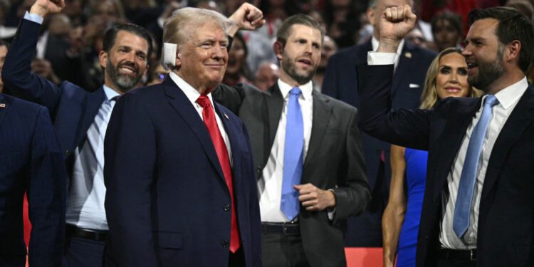 Donald Trump smiles as he is cheered on by his running mate J.D. Vance and his sons Donald Trump Jr. and Eric Trump during the first day of the 2024 Republican National Convention in Milwaukee.