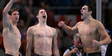 Gold medallists US' Caeleb Dressel, US' Hunter Armstrong, US' Chris Guiliano and US' Jack Alexy celebrate following the final of the men's 4x100m freestyle relay swimming event at the Paris La Defense Arena in Nanterre, west of Paris, on July 27, 2024. (Photo by SEBASTIEN BOZON / AFP) (Photo by SEBASTIEN BOZON/AFP via Getty Images)