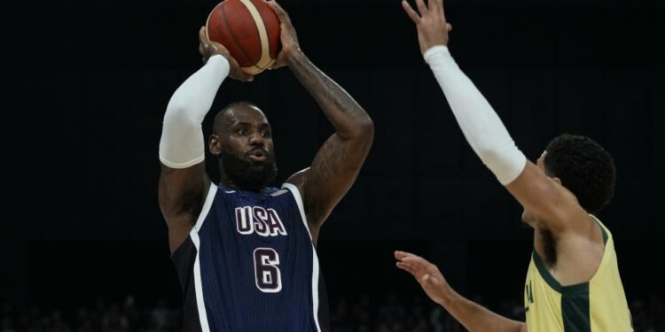 United States' LeBron James, left, looks to shoot as Australia's Josh Green, right, tries to block during the USA Basketball Showcase in Abu Dhabi, United Arab Emirates, Monday, July 15, 2024. (AP Photo/Altaf Qadri)