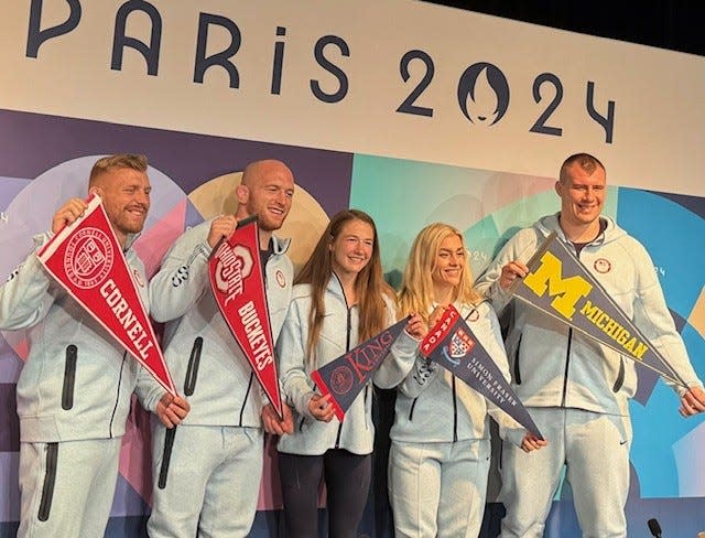 U.S. Olympic wrestlers hold their college pennants, including Ohio State's Kyle Snyder (second from left) and Michigan's Adam Coon (far right).