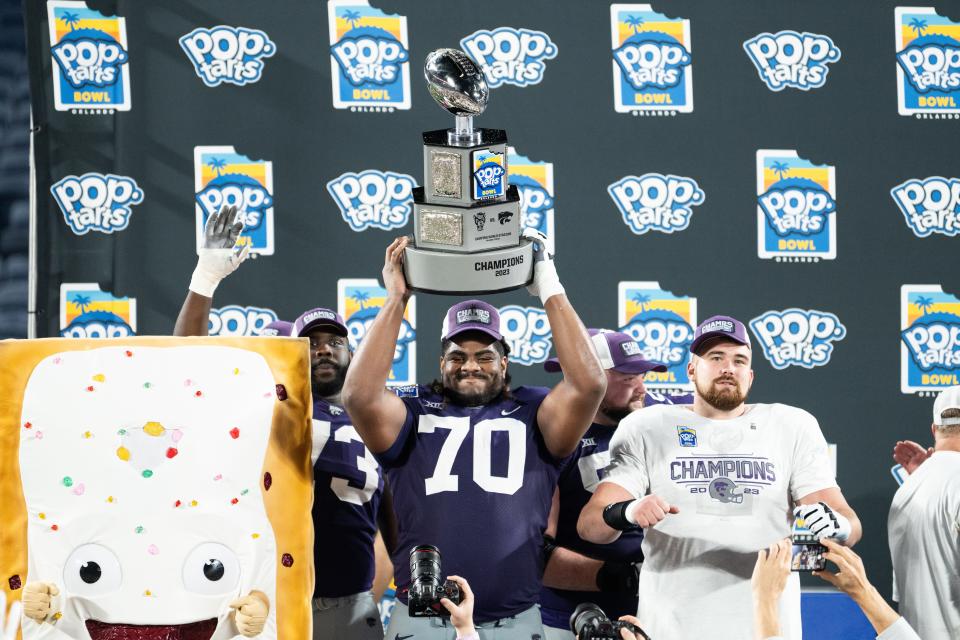 Dec 28, 2023; Orlando, FL, USA; Kansas State offensive lineman KT Leveston (70) celebrates the win against NC State after the game at Camping World Stadium. Mandatory Credit: Jeremy Reper-USA TODAY Sports