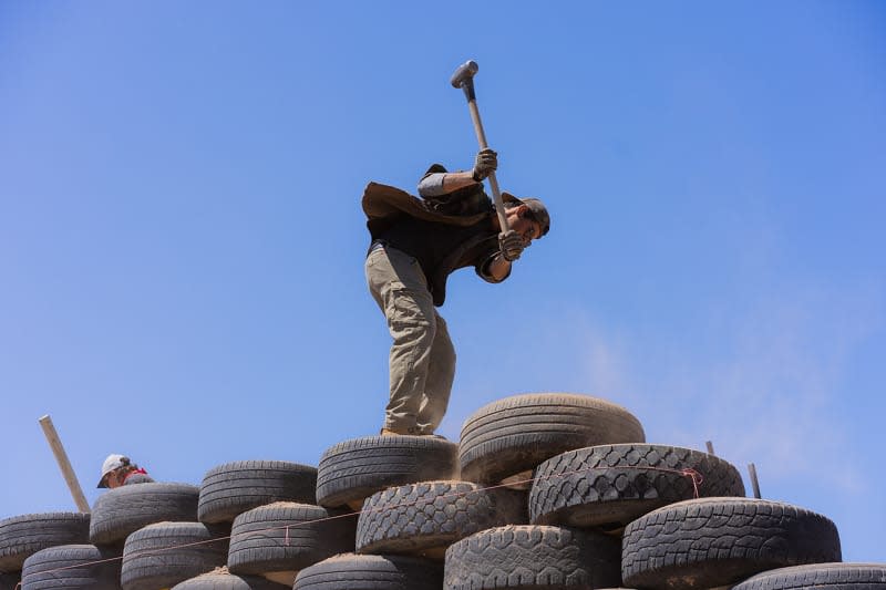 Someone working outside of earthship home.