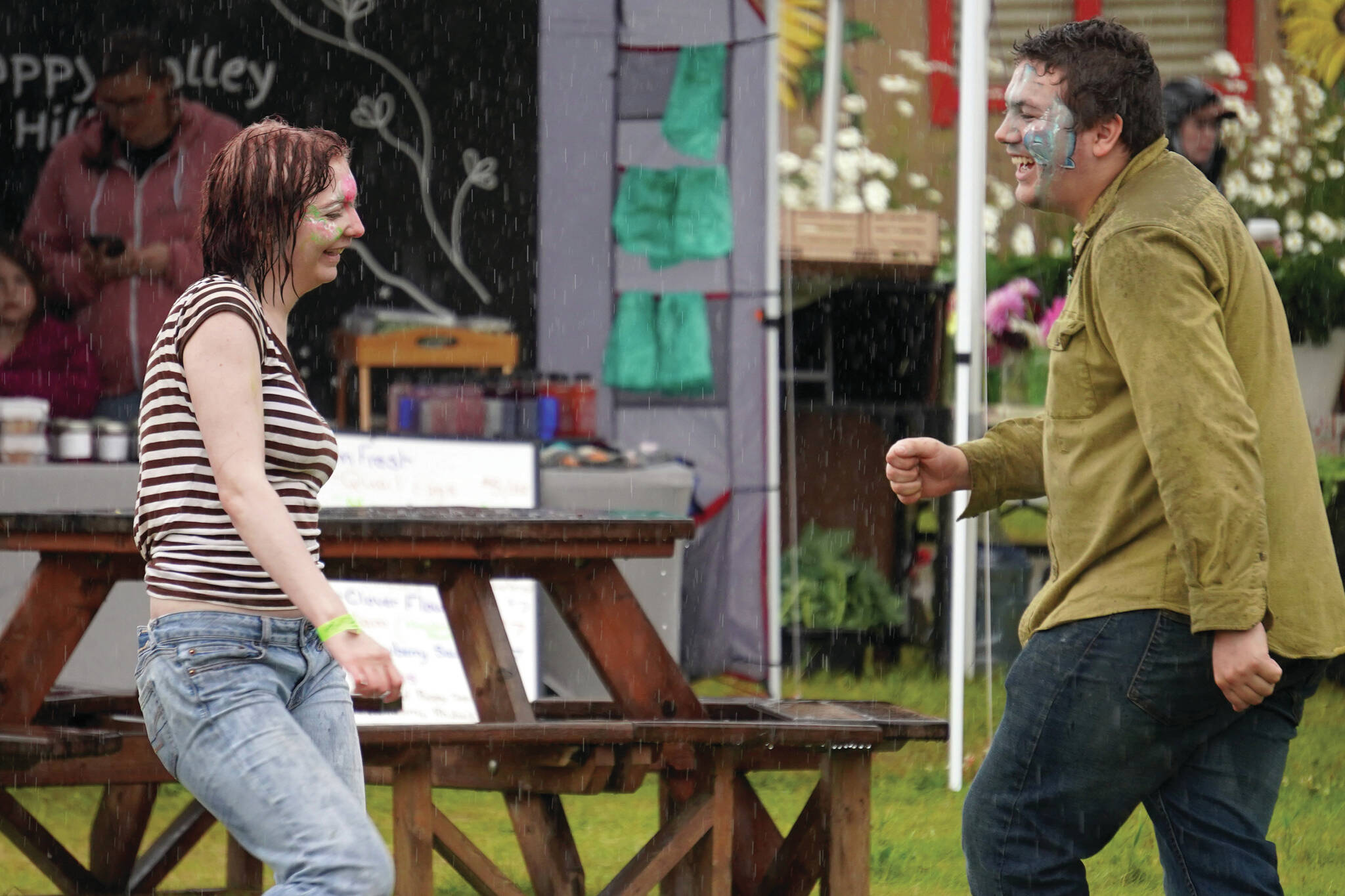 Attendees dance in the rain at the Kenai Peninsula Fair in Ninilchik, Alaska, on Friday, Aug. 11, 2023. (Jake Dye/Peninsula Clarion)