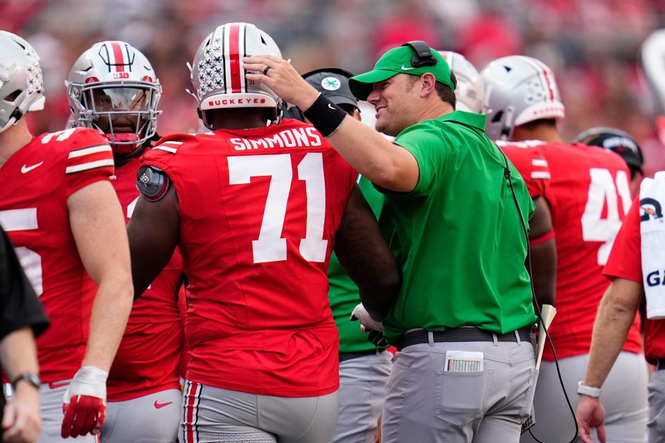 Sep 16, 2023; Columbus, Ohio, USA; Ohio State Buckeyes offensive lineman Josh Simmons (71) gets a pat on the back from coach Justin Frye during the NCAA football game against the Western Kentucky Hilltoppers at Ohio Stadium. Ohio State won 63-10.