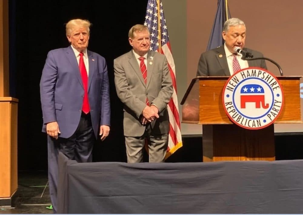 Former President Donald Trump looks on as new state GOP Chairman Chris Ager addresses the party convention in Salem, New Hampshire on Jan. 28. (Josh Rogers/NHPR)